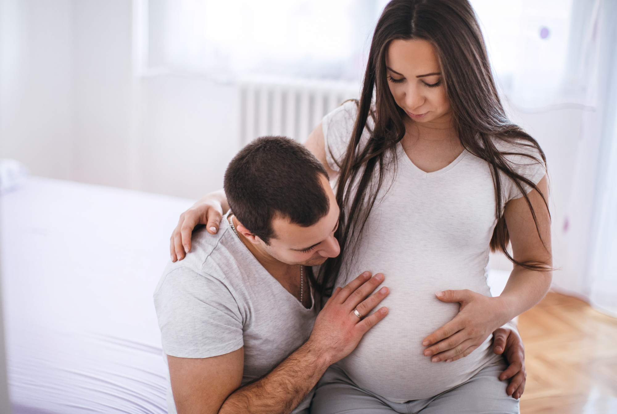 Pregnant woman being held by her male partner